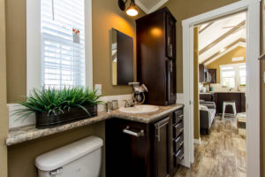 Image shows standard tissue holder, banjo countertop over commode, and standard towell bar installed.