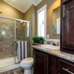Image shows standard rounded laminate countertops and standard medicine cabinet behind mirror in bathroom.