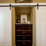 Picture shows upgrade to white craftsman rolling closet doors. White bi-fold closet doors are standard.