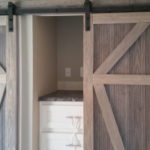 Picture shows upgrade to sliding barn doors on closets. White Bi-fold closet doors are standard.