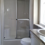 Standard white 1-piece fiberglass 48-inch shower and standard bathroom ventilation fan shown here.