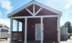 Picture shows optional 8 foot covered front porch with painted rails and crows feet trim gable.
