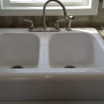 Image of upgraded white acrylic deep farm sink. Shows standard nickel faucet with spray. This model has been upgraded to HD laminate countertops throughout home.